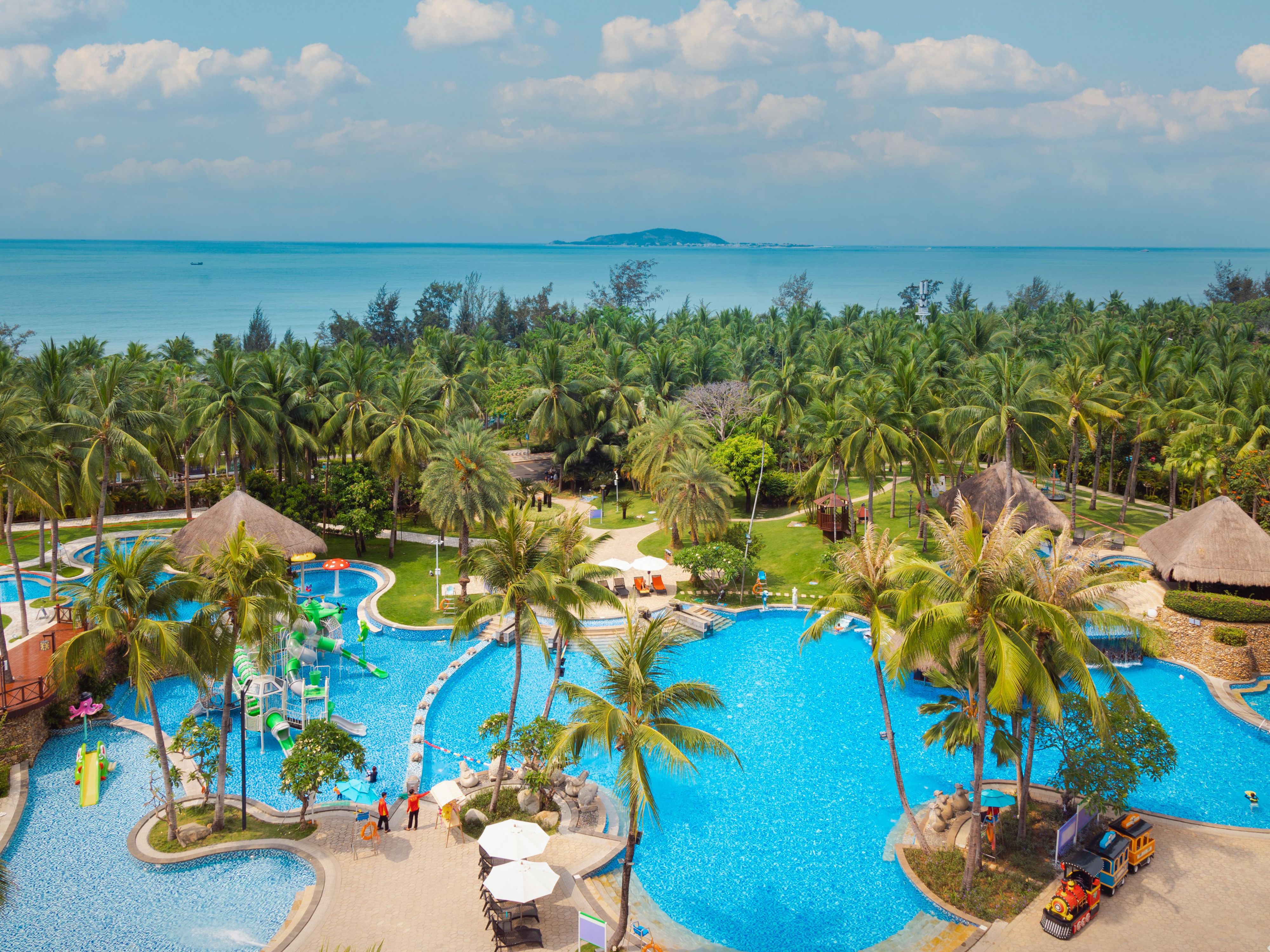 造型独特的室外泳池区占地约2100平米，由瀑布池、儿童浅水池、儿童水上滑梯池与成人池组合而成；形态各异的喷水雕像、热带风情的水中茅屋以及舒适的水流按摩，满足您和家人的畅游体验