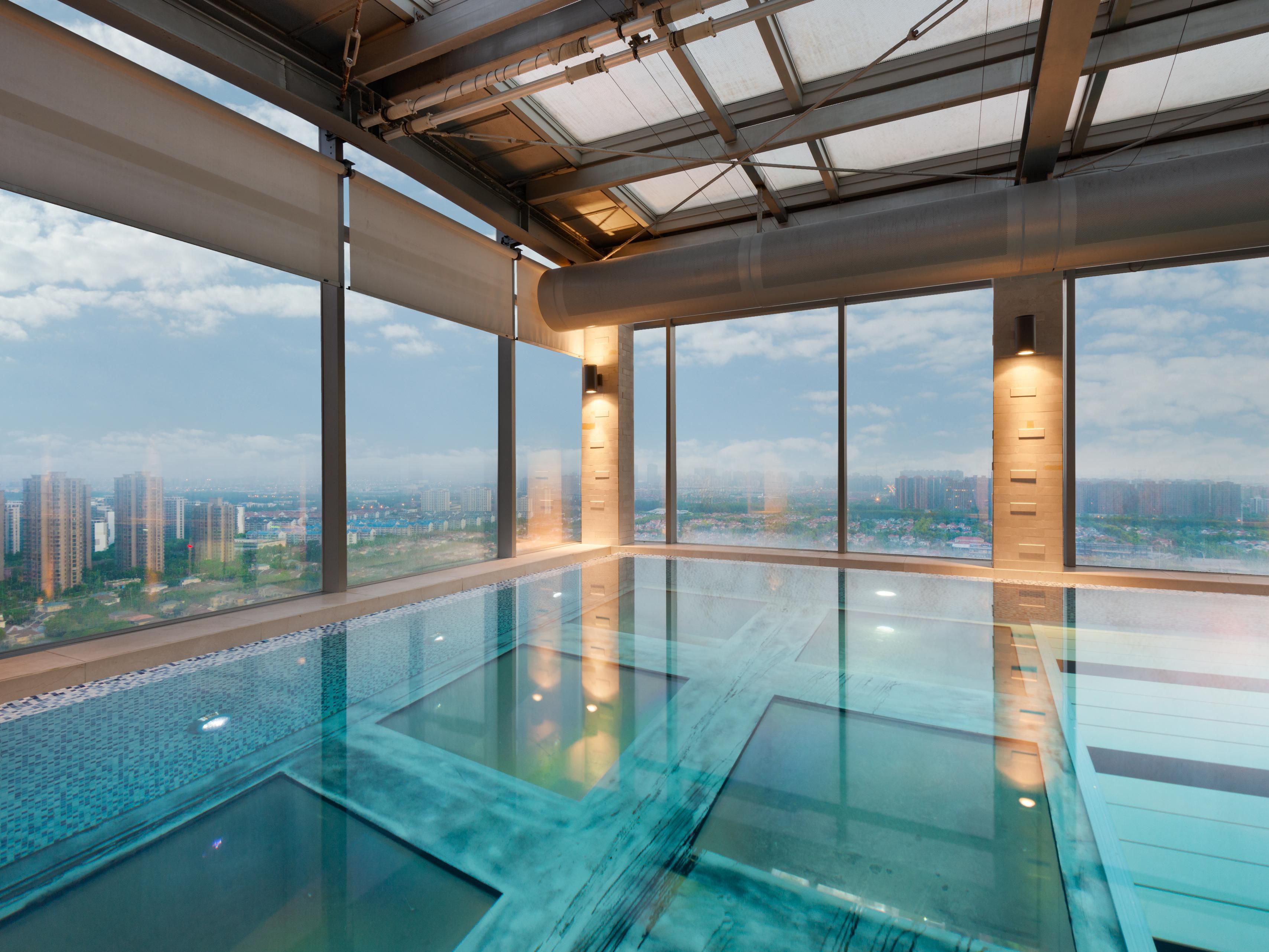 悬臂天幕泳池位于酒店24层，距离地面近100米，其独特得设计出自新加坡顶尖建筑建筑大师之手。泳池部分结构巧妙悬跳于主体建筑之外，底部更是采用了全透明材质，畅游其中仿佛置身云端，透过清澈的底部，城市街景尽收眼底，一览无遗。这不仅是一场视觉的盛宴，更是一次心灵的震撼之旅。