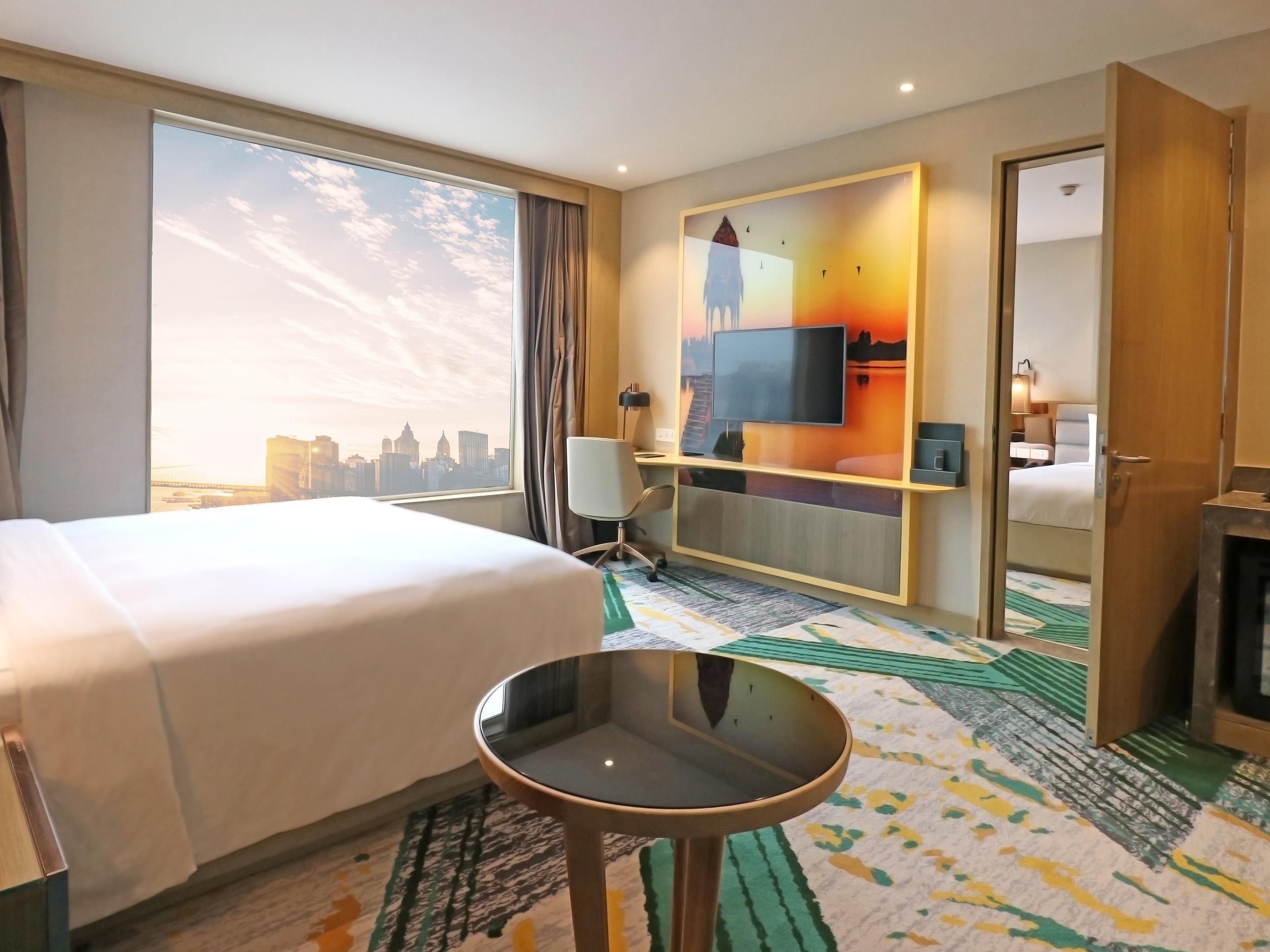 Modern rooms with large windows offering stunning views of the city skyline — comfort meets scenic charm.