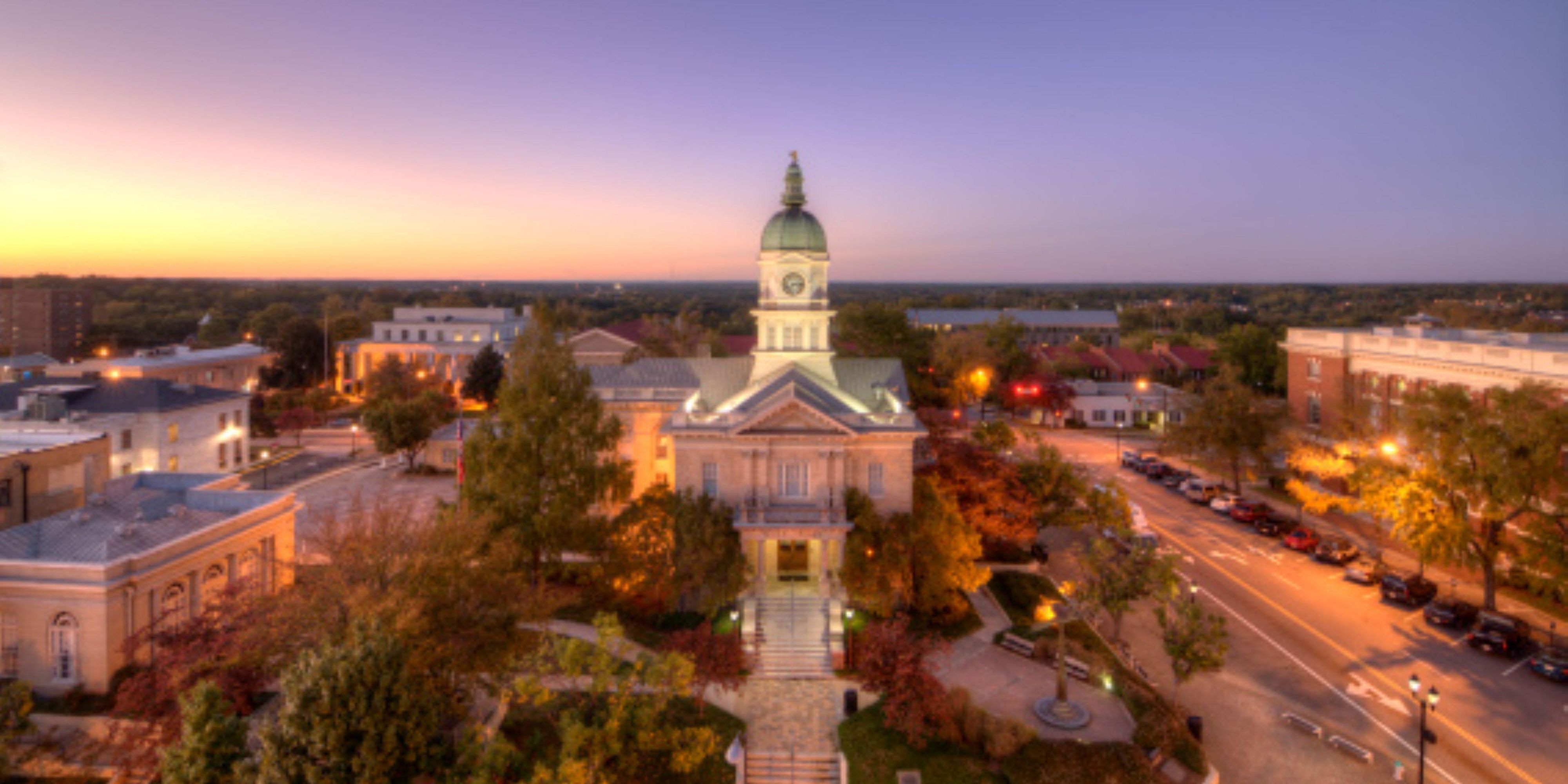 An aerial view capturing an illuminated historic civic building.