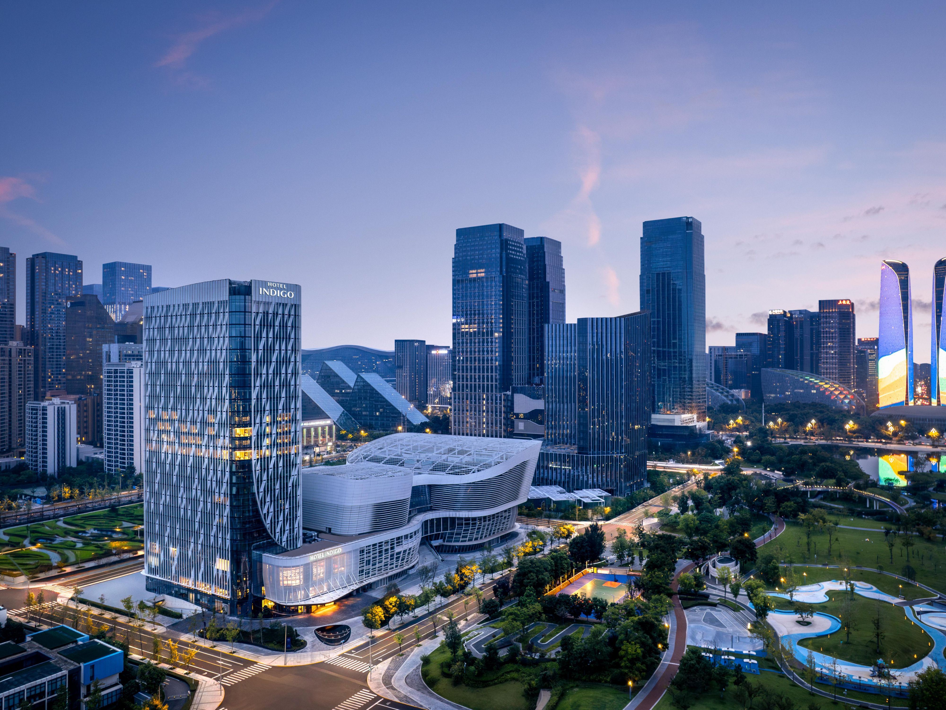 成都金融城英迪格酒店，坐落于交子金融商圈，与城市地标双子塔比邻，金融博物馆与交子公园也环绕在侧。步入酒店，益州府的金融文明基因融入当代设计之中。雕版鎏金墙面与元宝造型门厅映入眼帘，构树果吊灯巧妙呼应交子历史，钱币墙则娓娓道来金融的古今变迁。