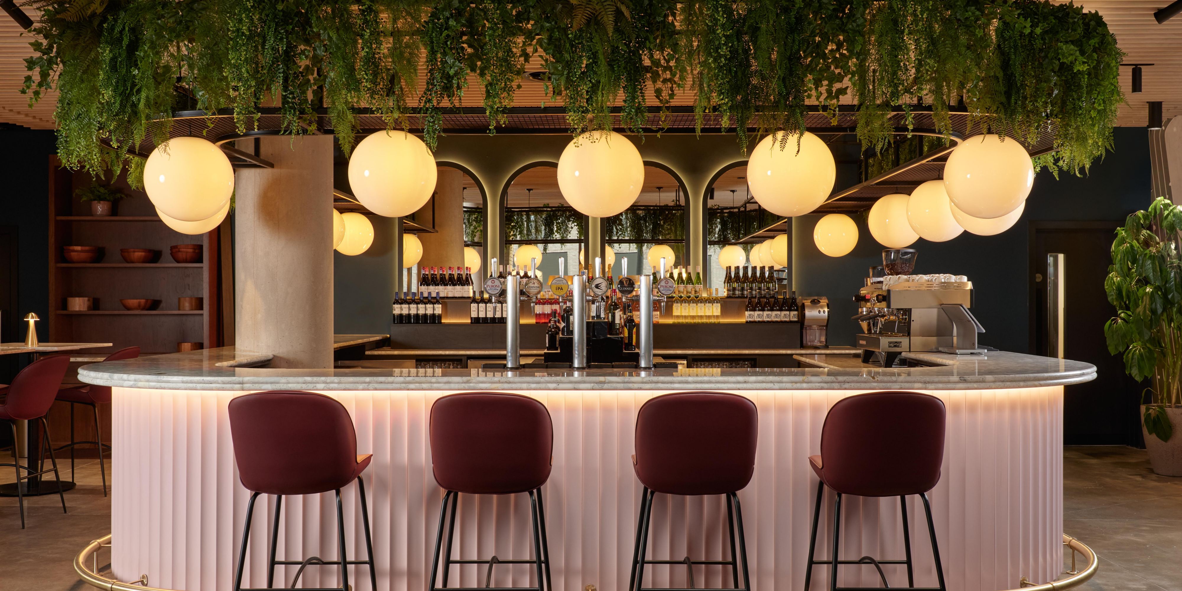 pink bar with circle overhead lights and green plants