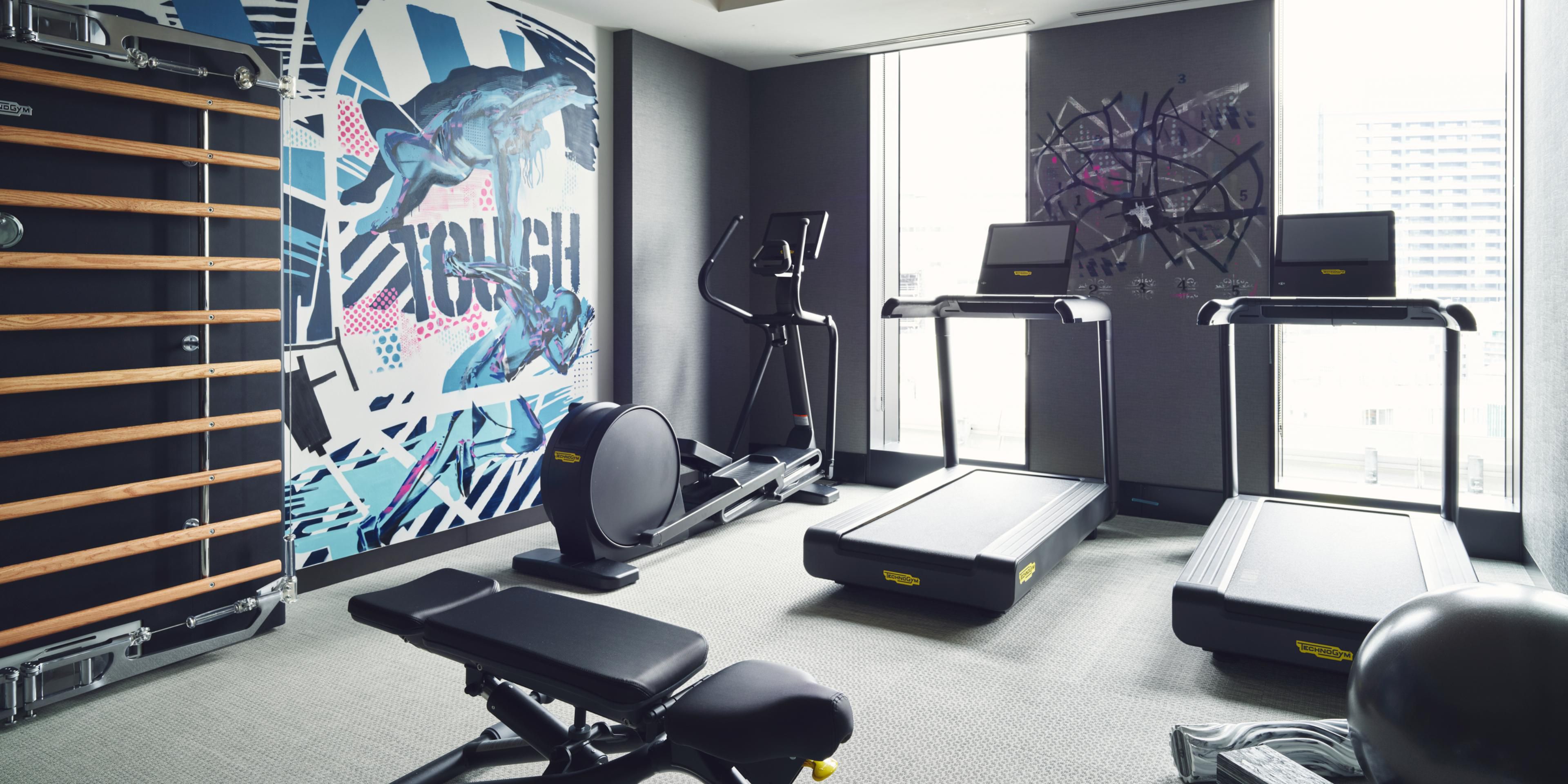 24/7 Gym with vibrant wall art for an immersive workout experience