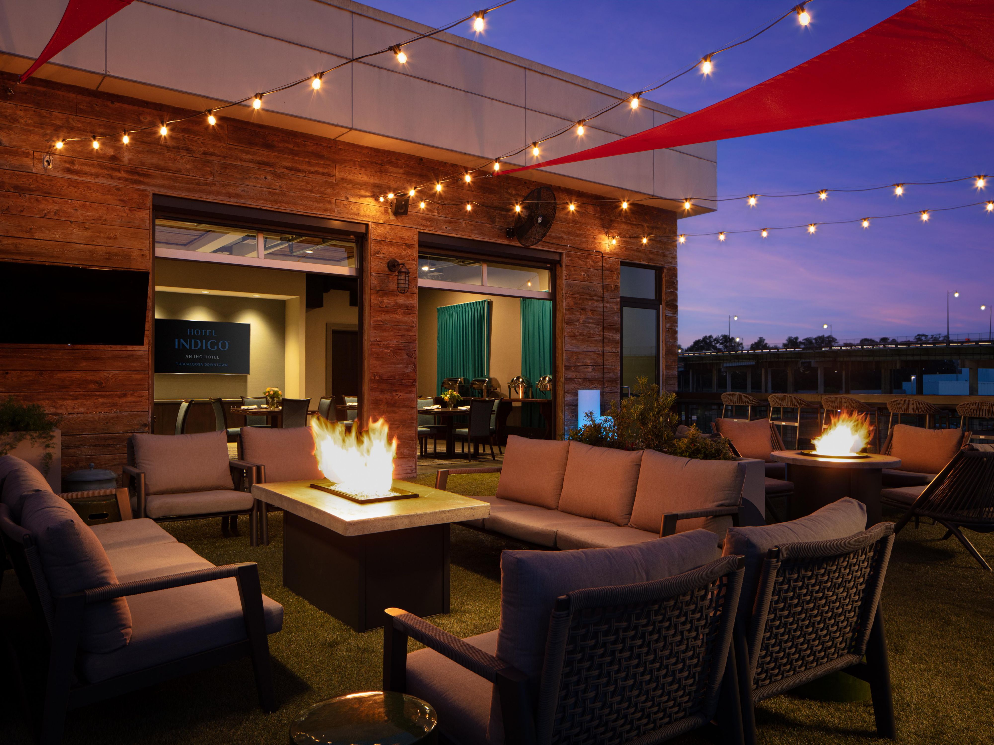 The Lookout is located atop the Hotel Indigo Tuscaloosa Downtown with stunning views of the Black Warrior River and downtown. Unwind with a cocktail near the fire pits or enjoy conversational seating with friends during happy hour. The Lookout is close enough to the Tuscaloosa Amphitheater so you can hear the live music from the rooftop.