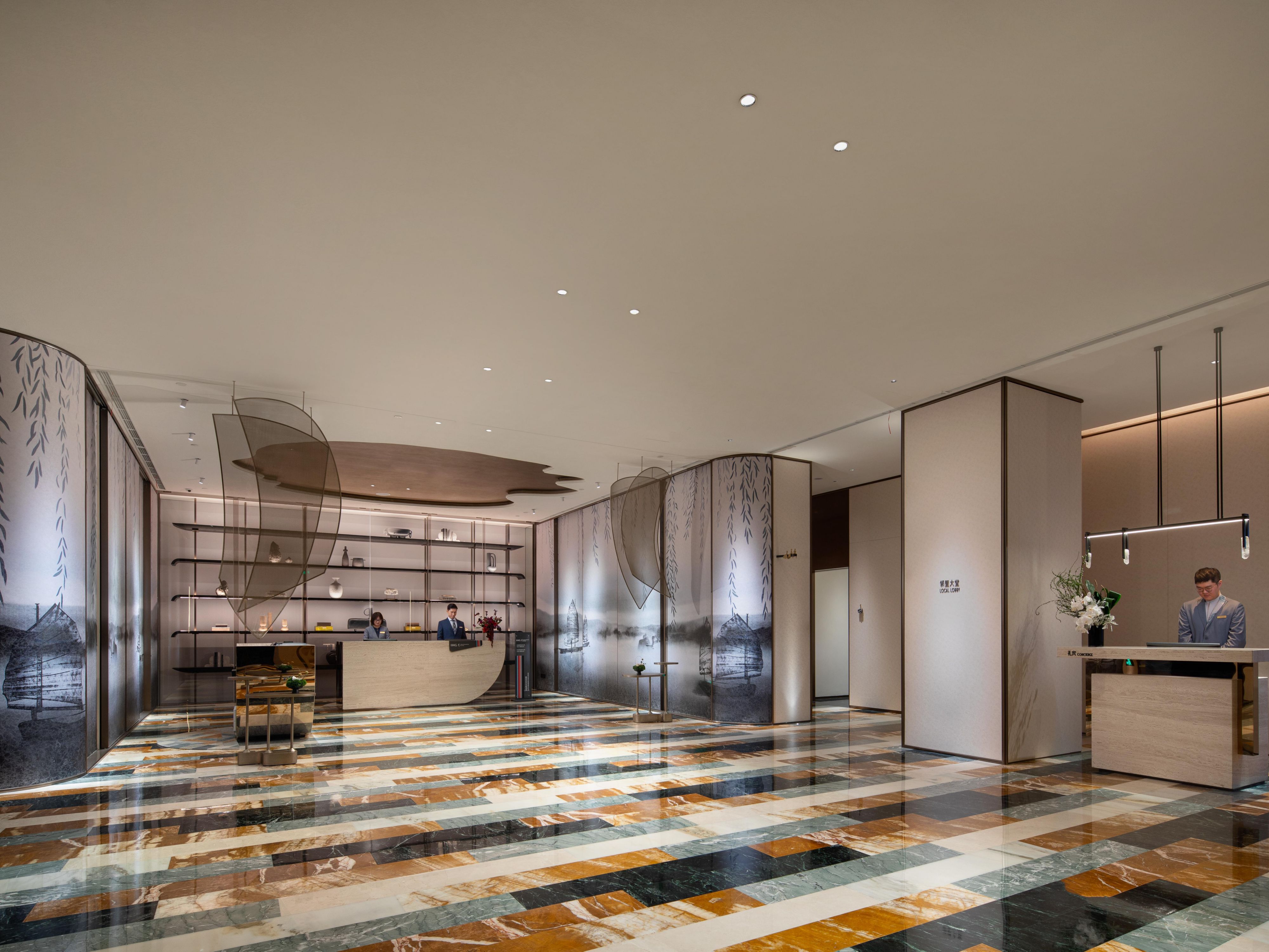 ⽆锡北倚⻓江，南濒太湖。诗⼈盛赞的太湖⽔， 湖泽千年。酒店大堂的设计融入了太湖的元素。
“太湖剪影”——接待台的天花板造型设计
“泛⾈湖上”——帆船造型的接待台