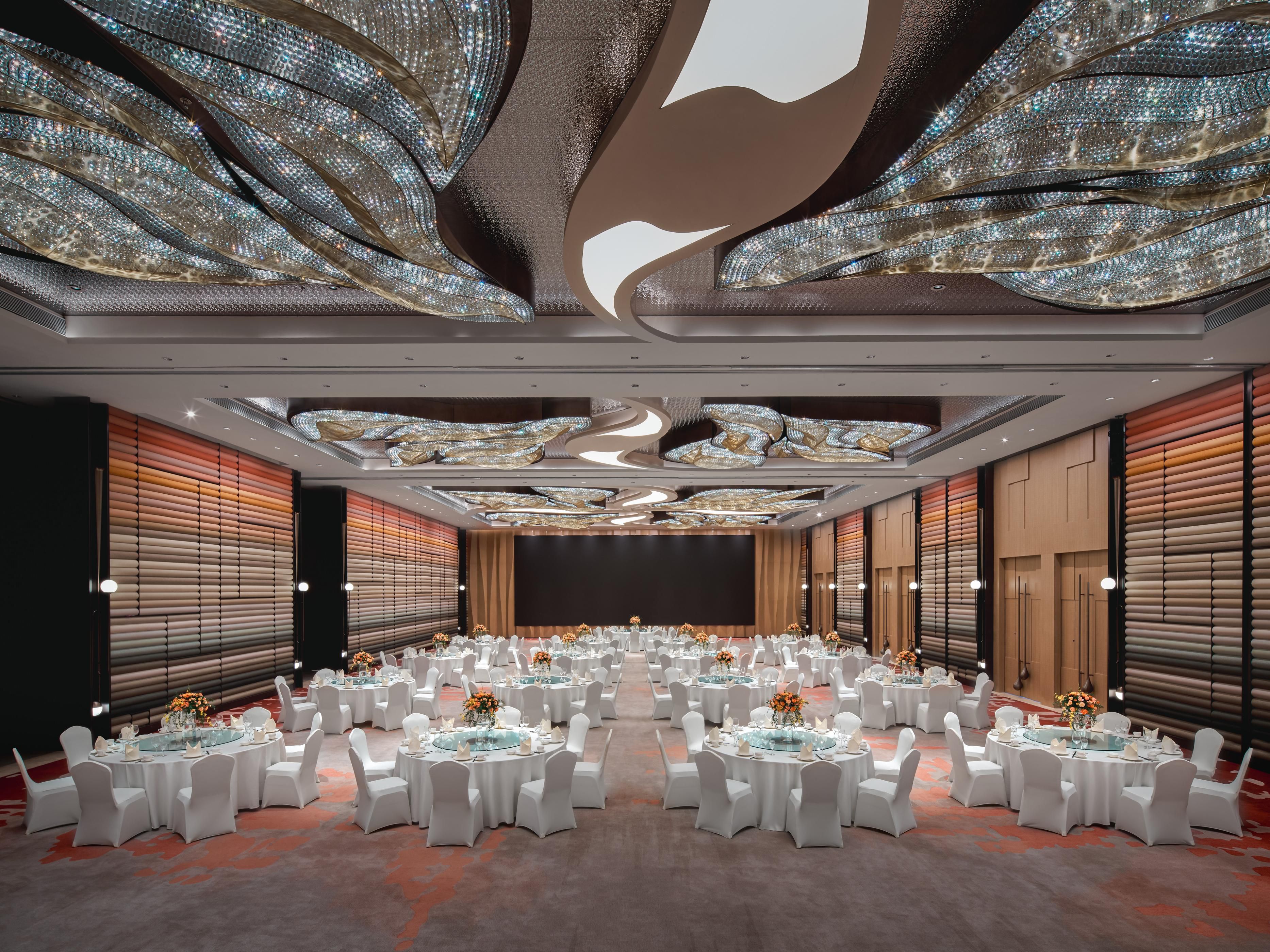 酒店拥有超过2,000平方米的会议与宴会空间，设计以山海为背景，运用鲜艳热烈的色彩，营造出既具地方特色又充满活力的氛围。其中，800余平米的大宴会厅，灵活多变，可分隔为3个厅使用，前厅全落地玻璃窗让您在会议之余尽享海景之美。此外，或可欣赏碧海波澜，或可一览大堂妙景，亦或沐浴自然光的4个多功能厅，连同1个新娘房，满足您不同活动的需求。酒店户外露台，是举办个性婚礼和私人派对的清雅之境。酒店专业的团队为您量身定制个性化方案，提供精致茶歇与晚宴，确保每一场活动都别具一格，让每位宾客留下难忘回忆。