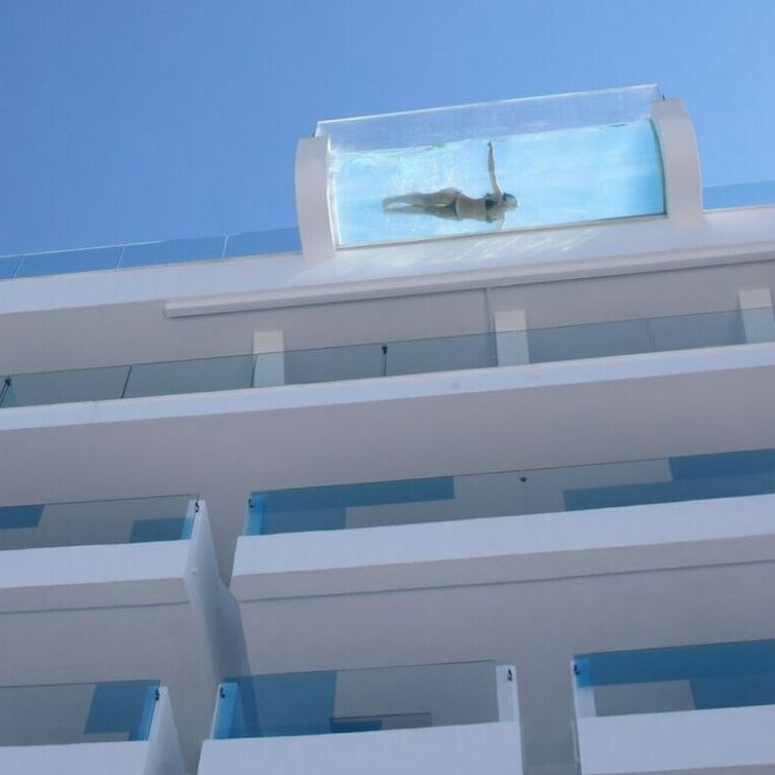 一位女士在私人悬挑的泳池中惬意漂浮，放松身心。