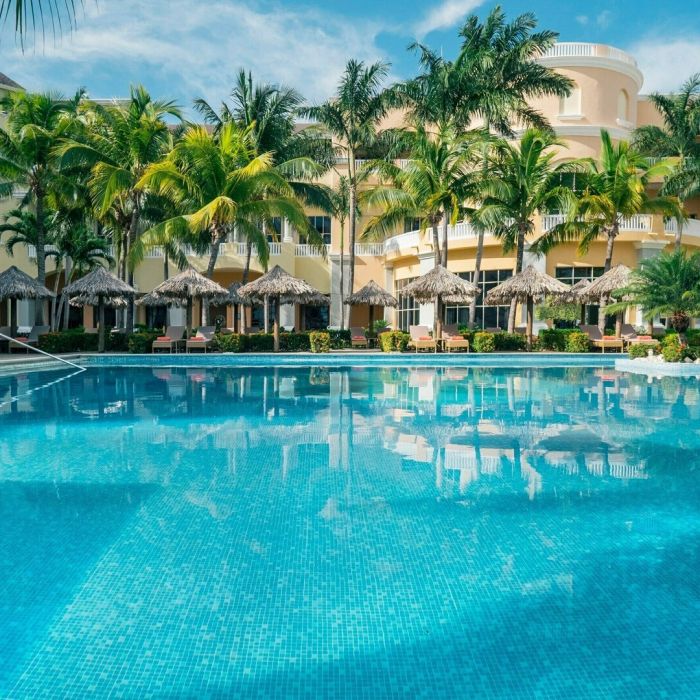 A serene view of a sparkling pool and palm trees at a resort in Jamaica.
