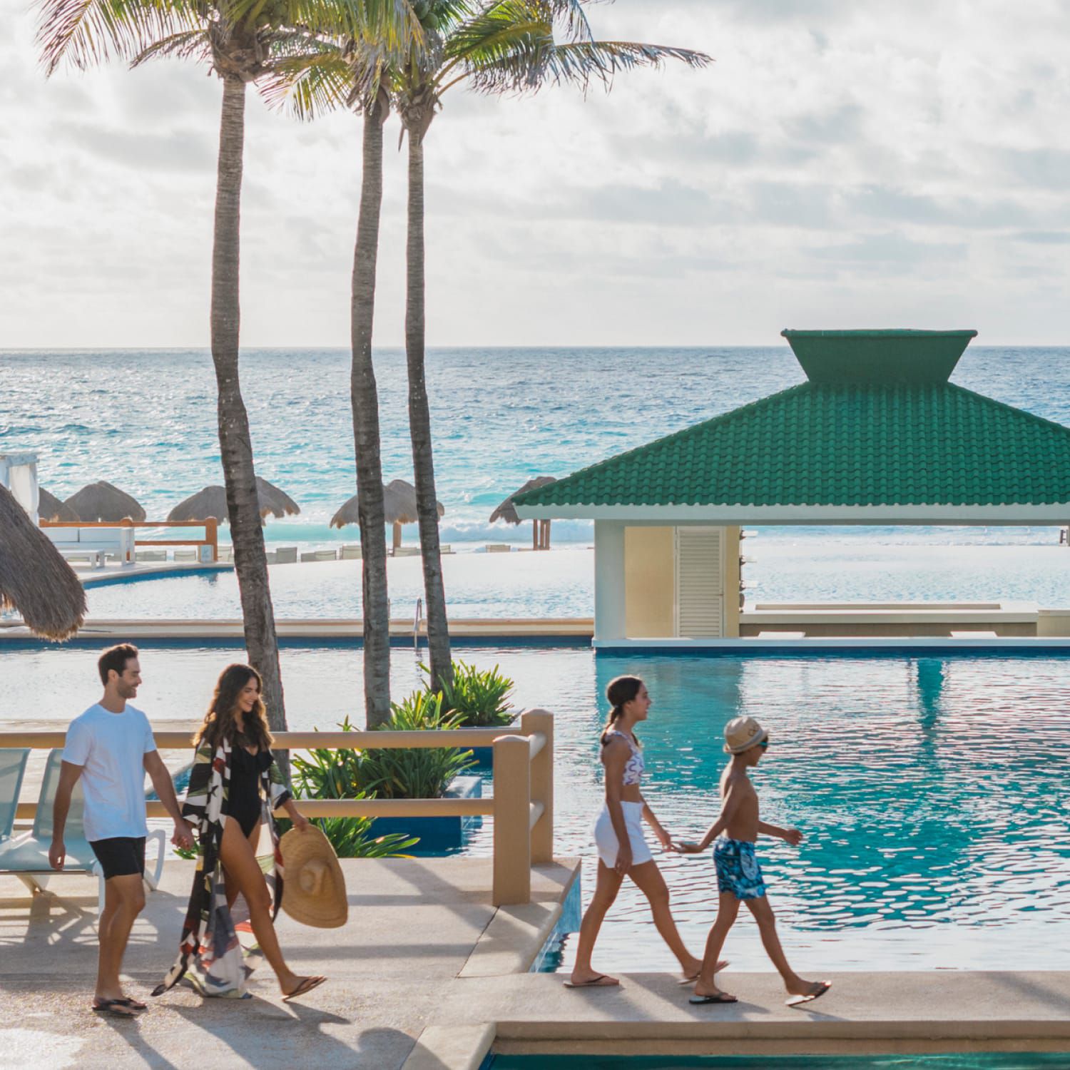Family walking along beachside pool