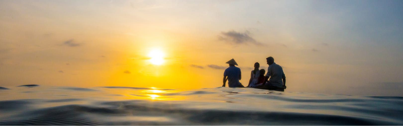Family on ocean boat excursion at sunset