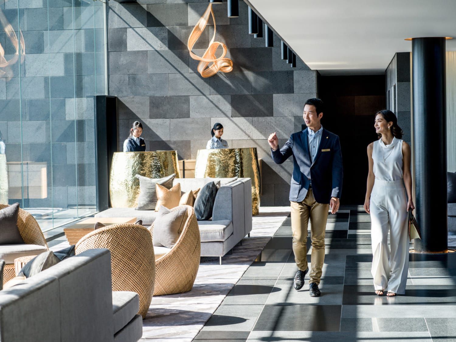 A couple walking through a lobby area with modern furniture