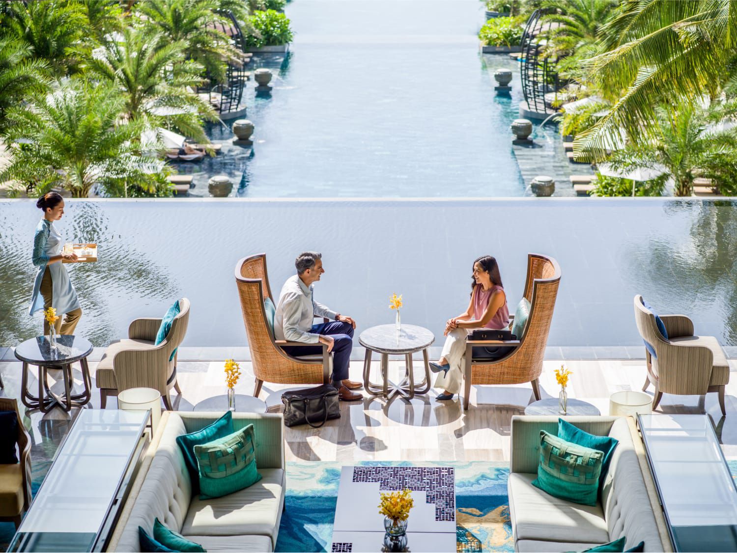 一对情侣在可俯瞰海景的屋顶户外餐厅用餐