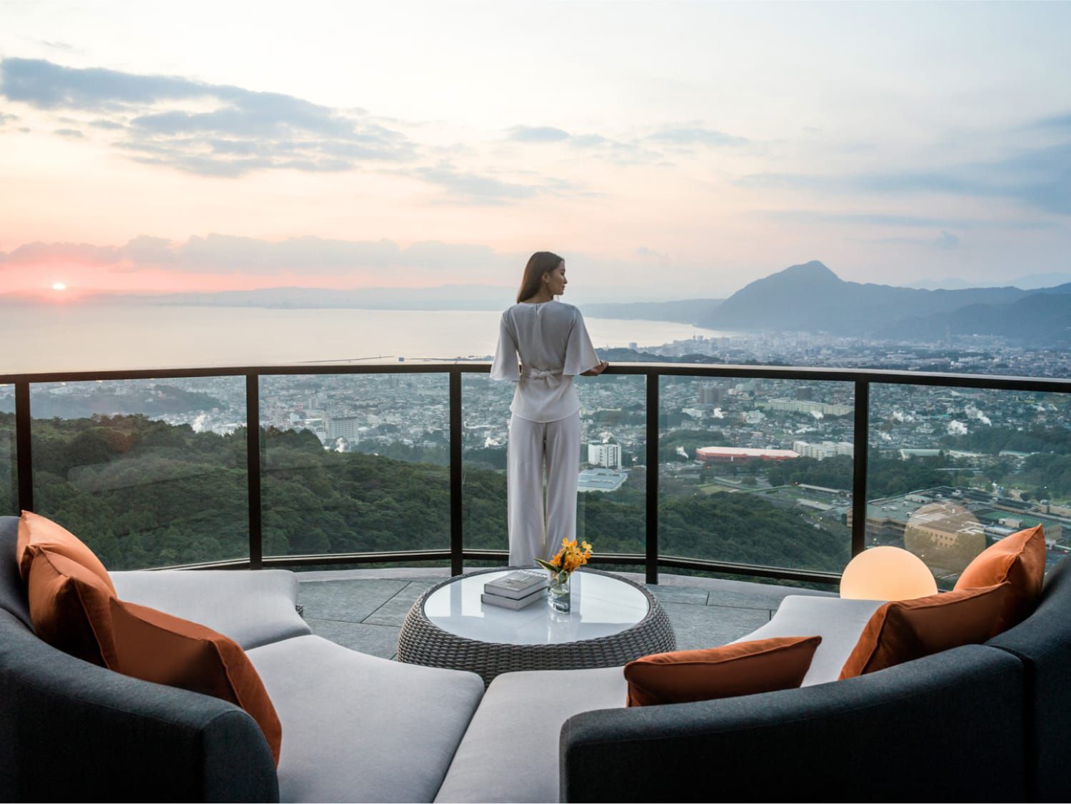 一位女士俯瞰着令人惊叹的山景和海洋美景