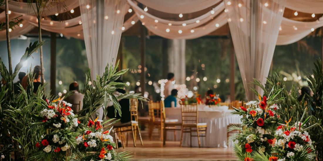 Tropical indoor outdoor wedding reception at dusk