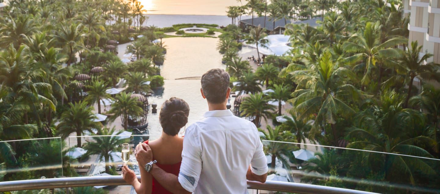 a couple arm in arm looking at the ocean view