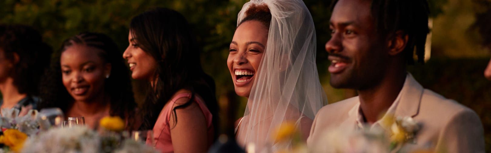 couple and guests laughing during wedding reception