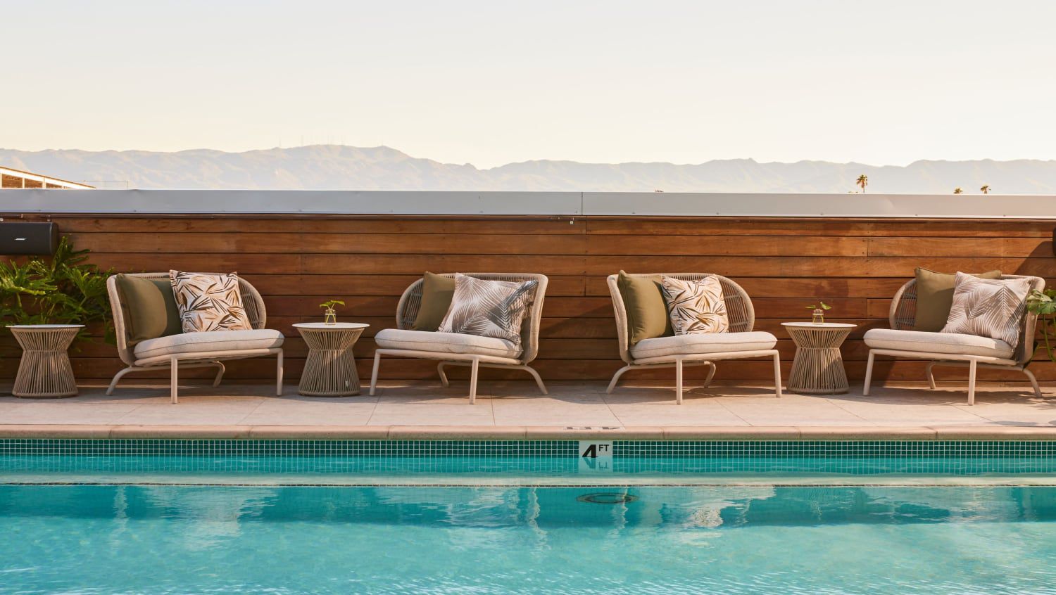 A rooftop for socialising by the pool with mountain views in the distance.