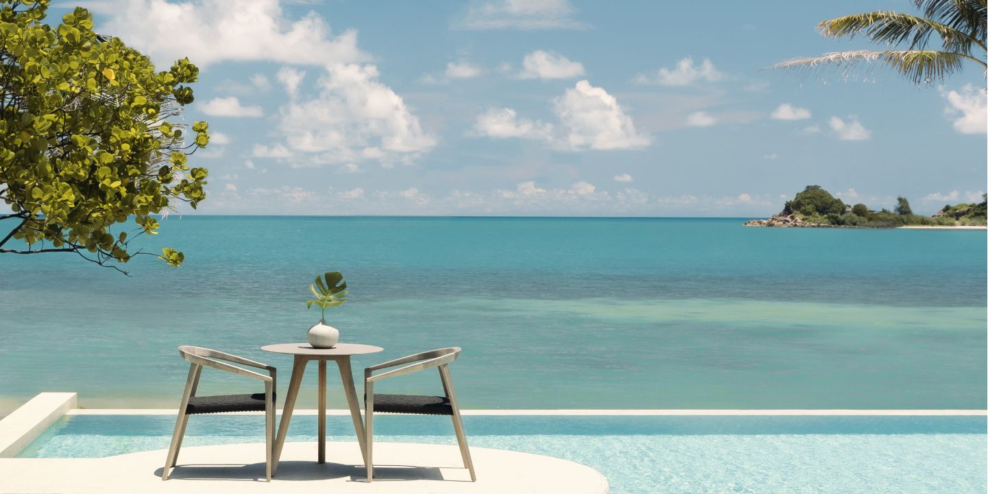 Dining table suspended over oceanside infinity pool