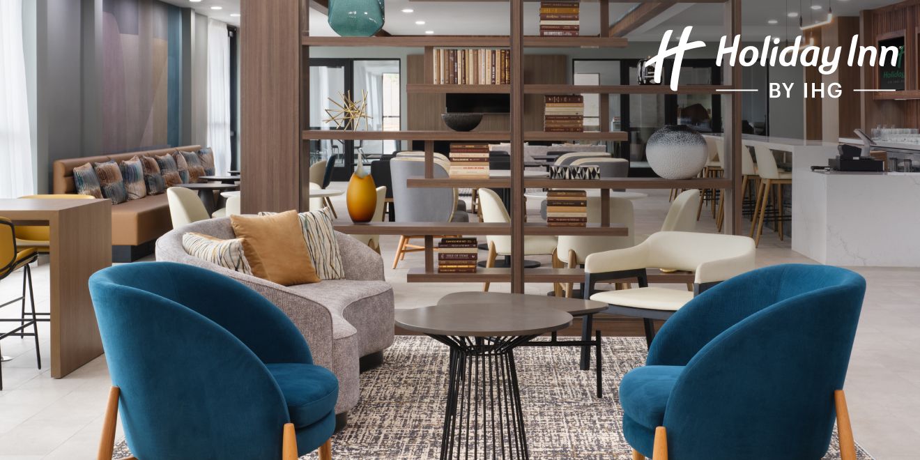 A modern hotel lobby with sleek furniture and spaces for relaxing and working.