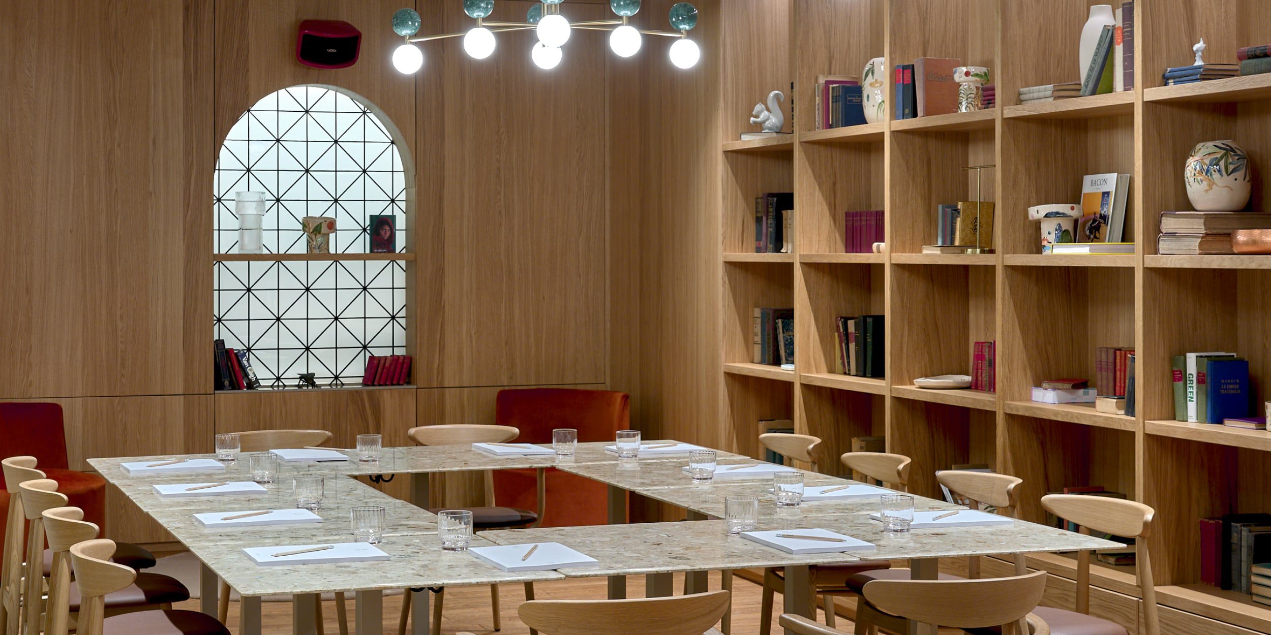 Modern meeting room with wood decor and marble tables.	