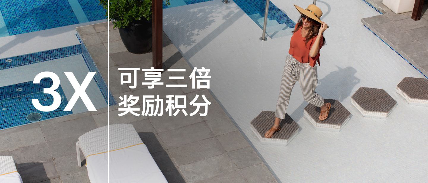 在迪拜 voco 酒店泳池甲板上漫步的女士