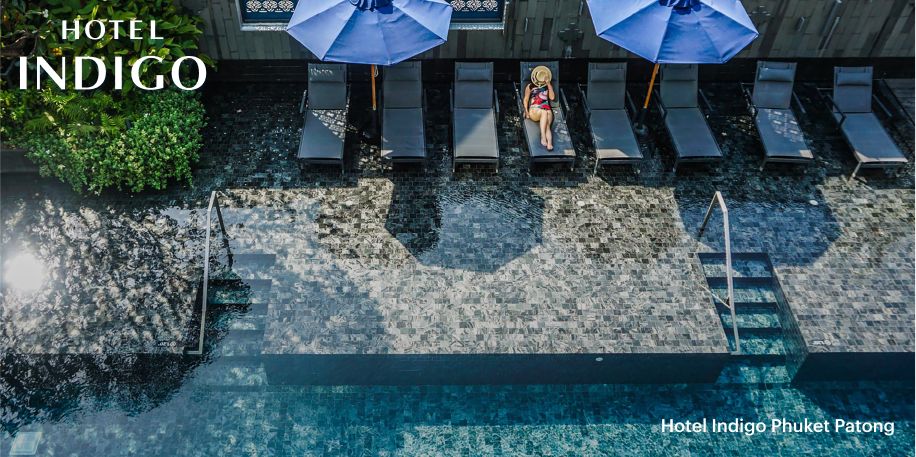  普吉岛巴东英迪格酒店的大型浅水池和休闲池，开阔的水域中放置了多把休闲躺椅。