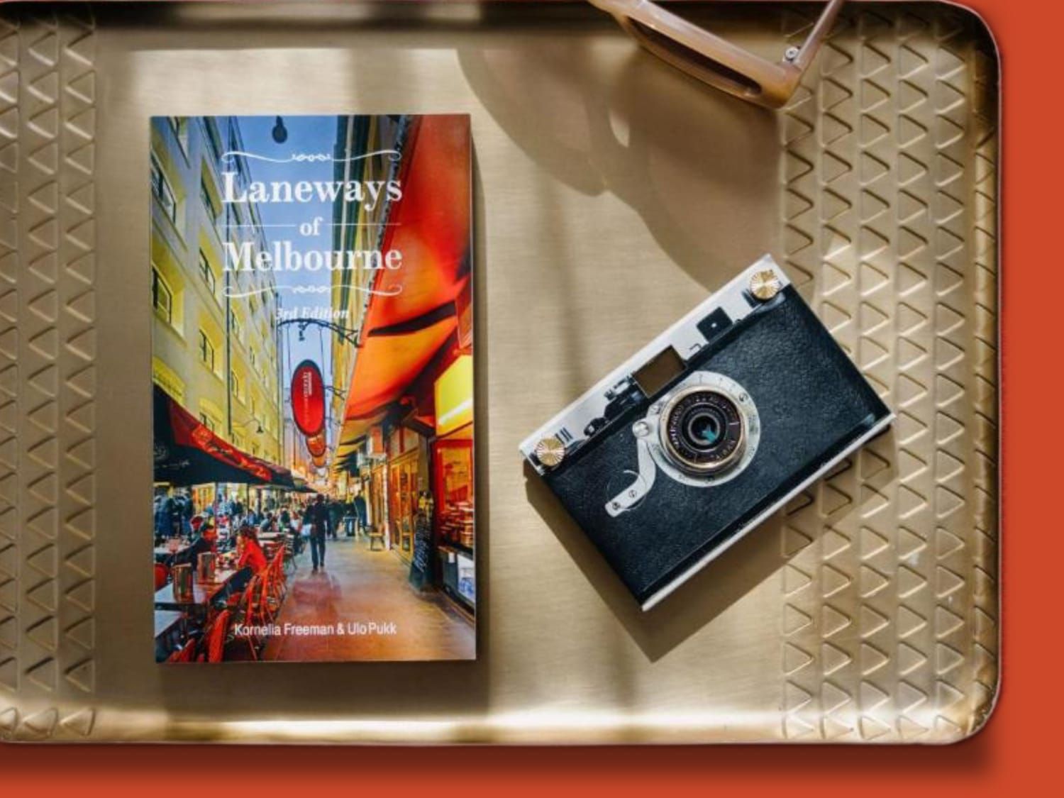‘Laneways of Melbourne’ book and vintage camera displayed on a tray