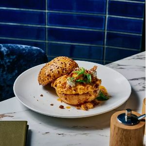 Gourmet breakfast sandwich on marble table with tiles