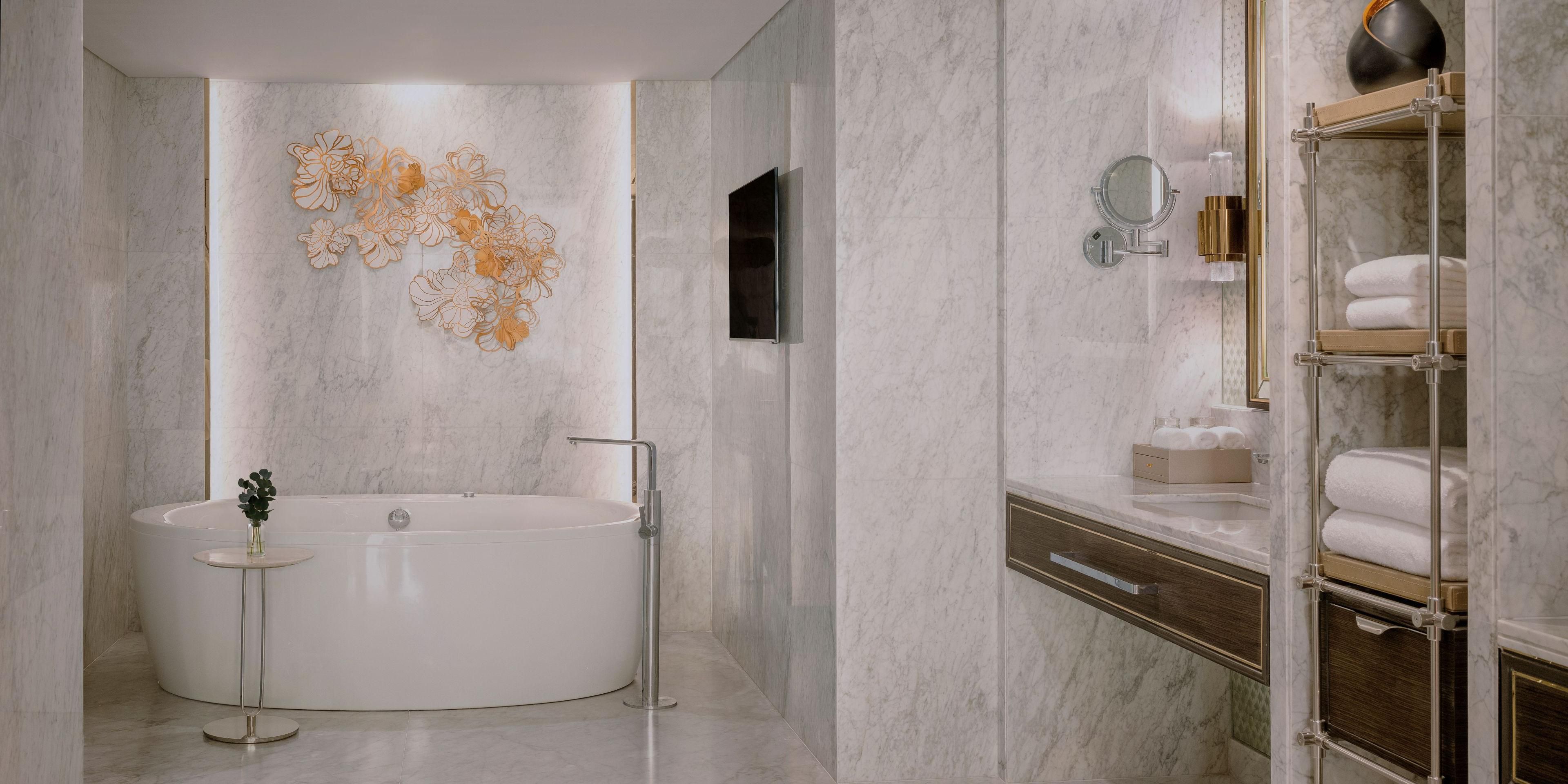 Indulge in luxury with complimentary Chopard wash amenities in your ensuite, featuring a spacious rain shower and a separate tub for ultimate relaxation.