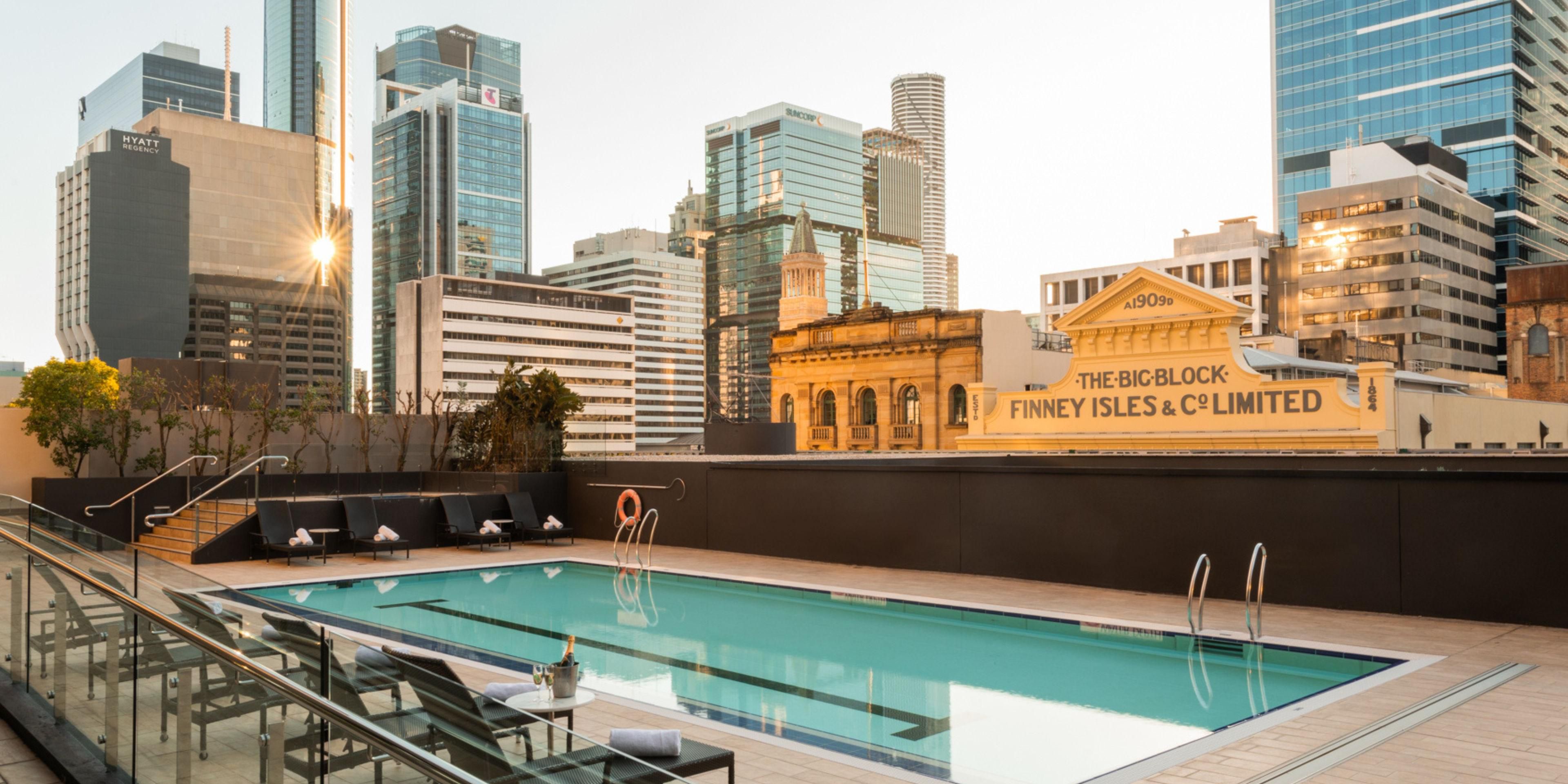 Outdoor inground swiming pool surrounded by the city skyline 
