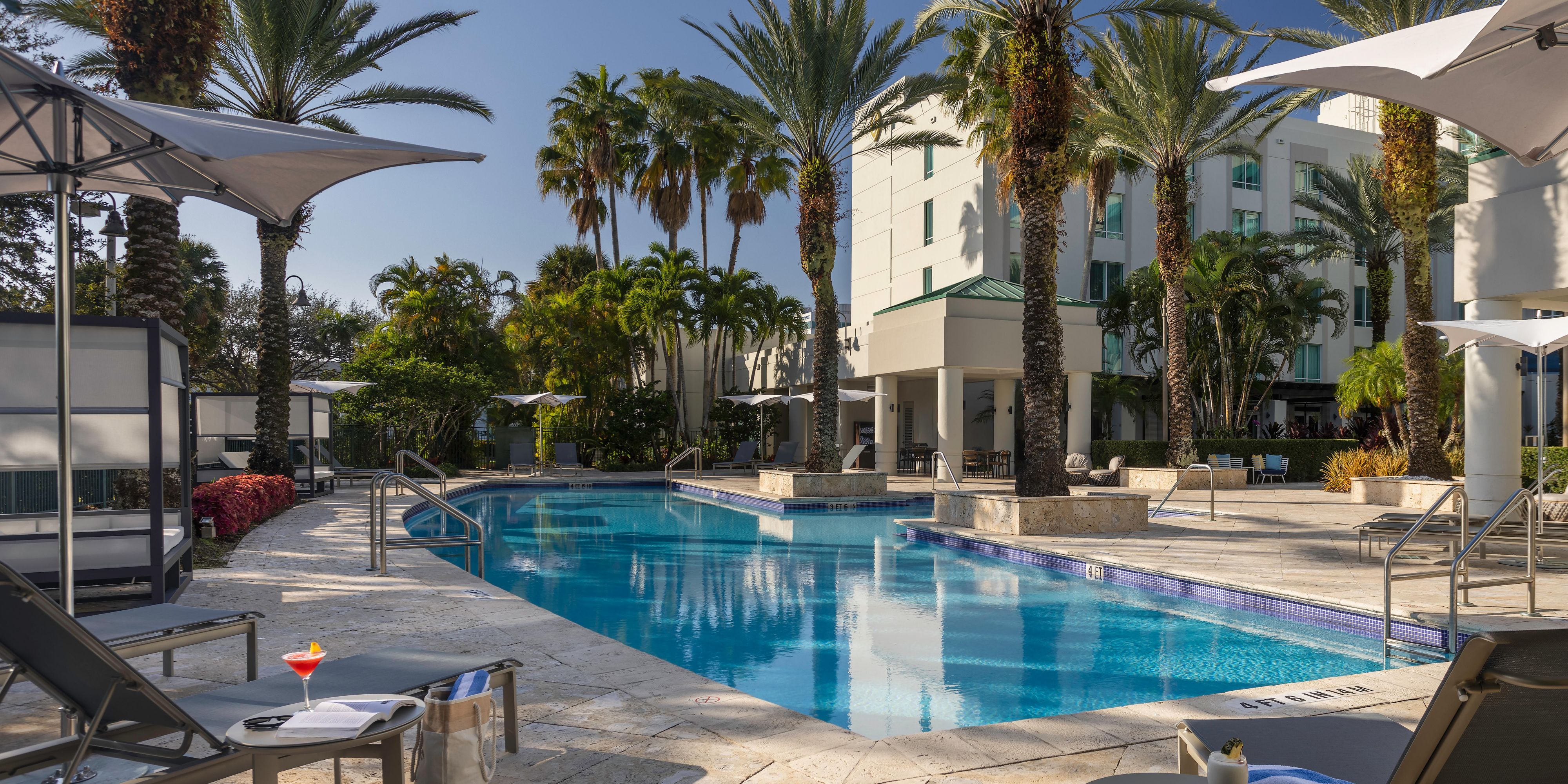 Escape to tranquility in our beautifully landscaped outdoor pool area, surrounded by lush palm trees and ample lounge seating. Whether you’re enjoying a morning swim or unwinding after a day of business meetings, our heated pool provides a serene retreat. Poolside service with refreshing beverages and light bites ensures every moment is effortless.