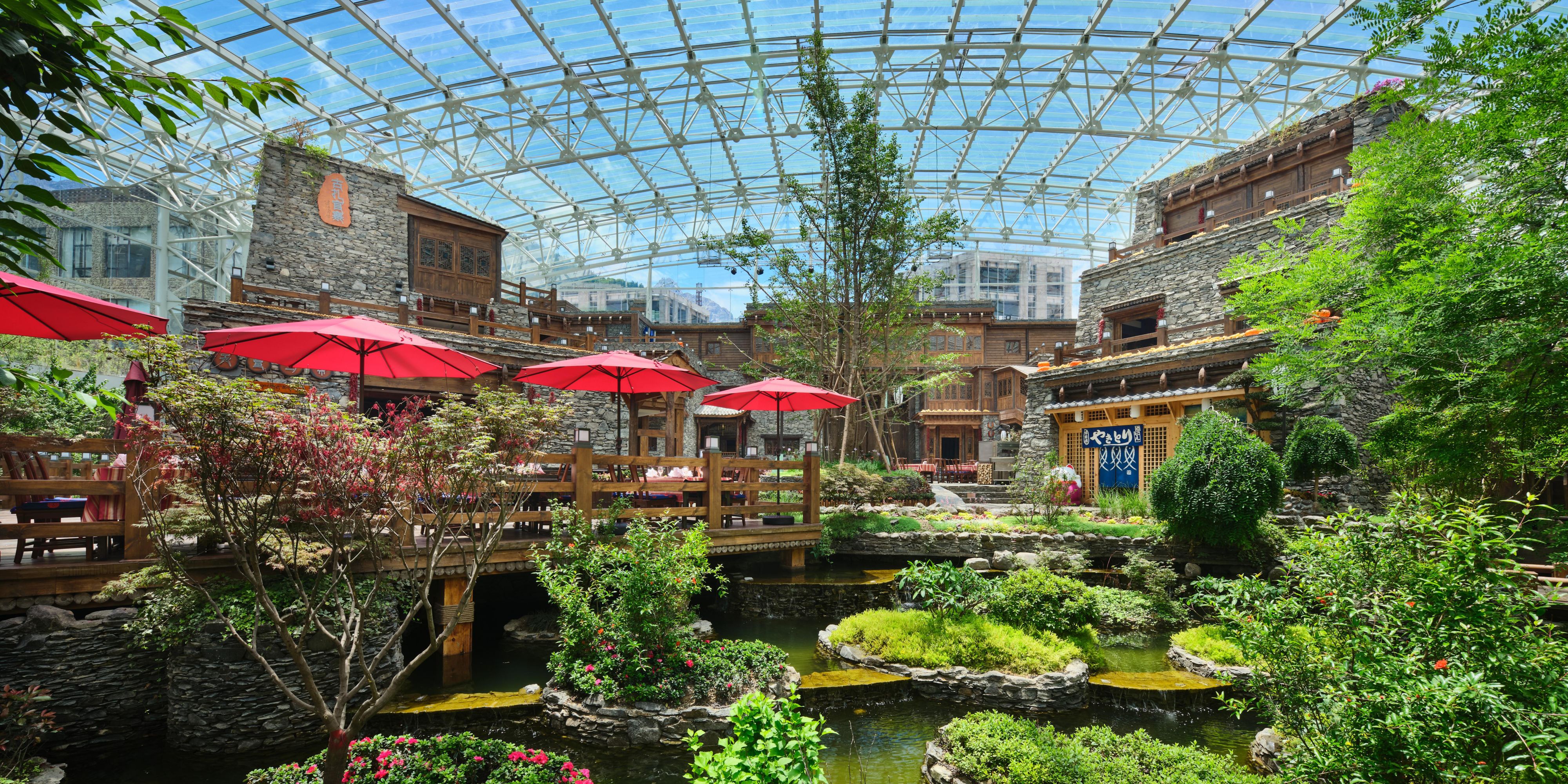 位于玻璃穹顶下的生态大堂，设有古树、花卉与池塘等景观，并汇集了酒店的全部餐厅，为宾客提供沉浸于自然之中的用餐环境