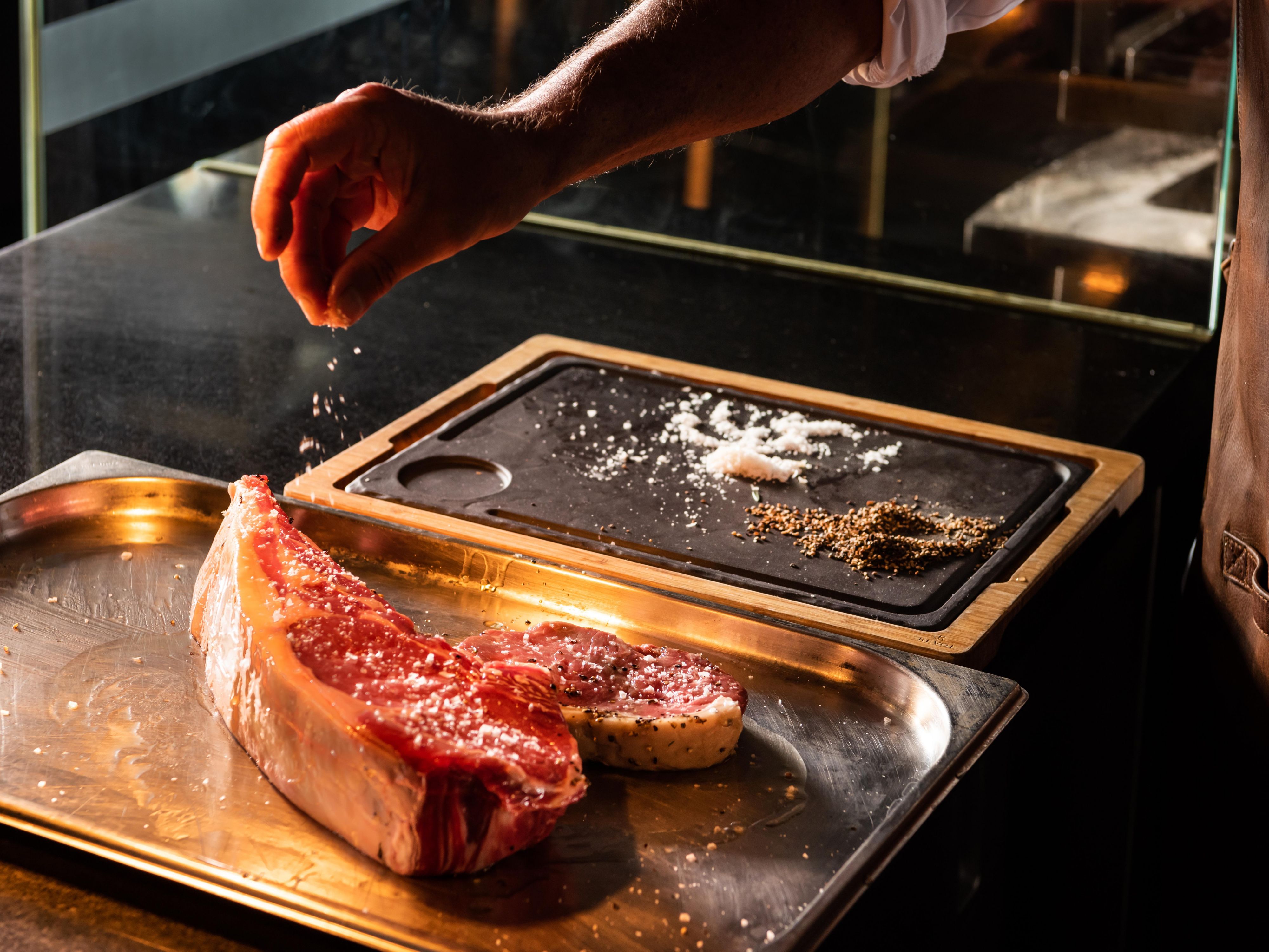 chef seasoning a steak