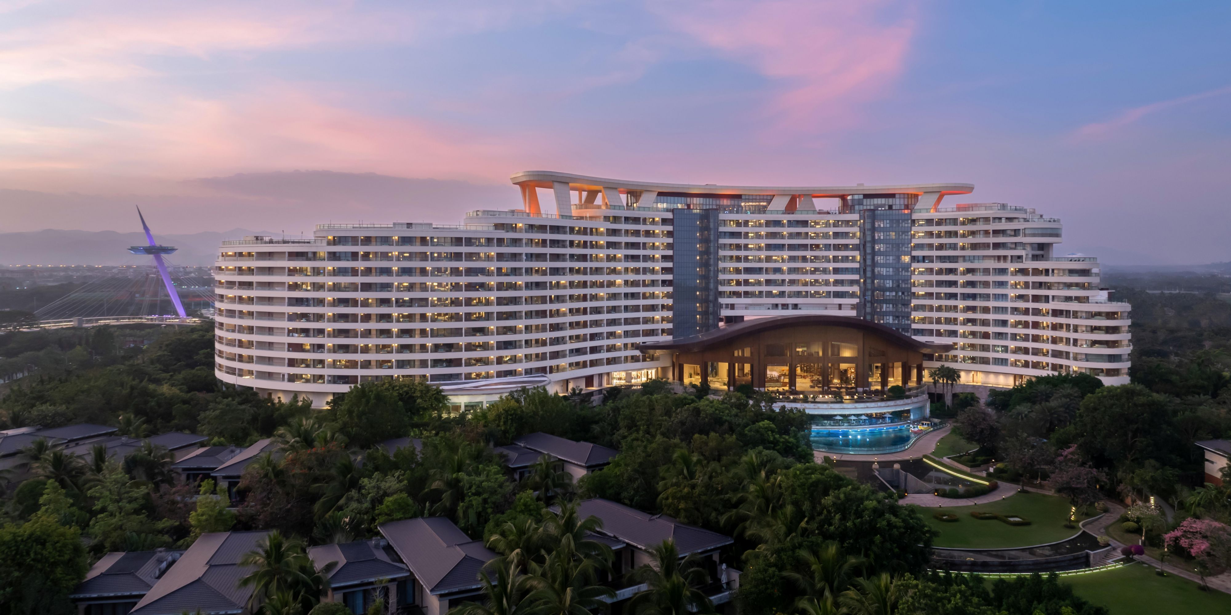 酒店位于“国家海岸”海棠湾核心地带，坐拥碧波万顷与纯净幼沙，背倚郁郁葱葱的绵延椰林，更与三亚国际免税城咫尺之遥。酒店建筑宛若一条巨龙，傲然立于15万平方米的滨海画卷之上，设计以现代海岛风情为精髓，空间开阔清逸。3,000平方米的开放式大堂将海岛的壮丽景致全然收纳，海天一色，豁然开朗。295间客房配置臻至卓越，每一处观景角度皆经精心雕琢。于此下榻，可私享一片蔚蓝，聆听涛声絮语，开启一段铭刻于心的奢华度假体验。