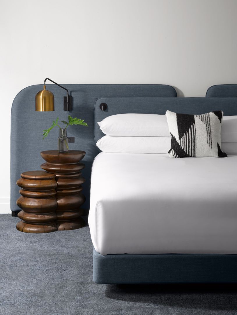 纯白的床，搭配乡村风格的木雕边桌和灰色床头板