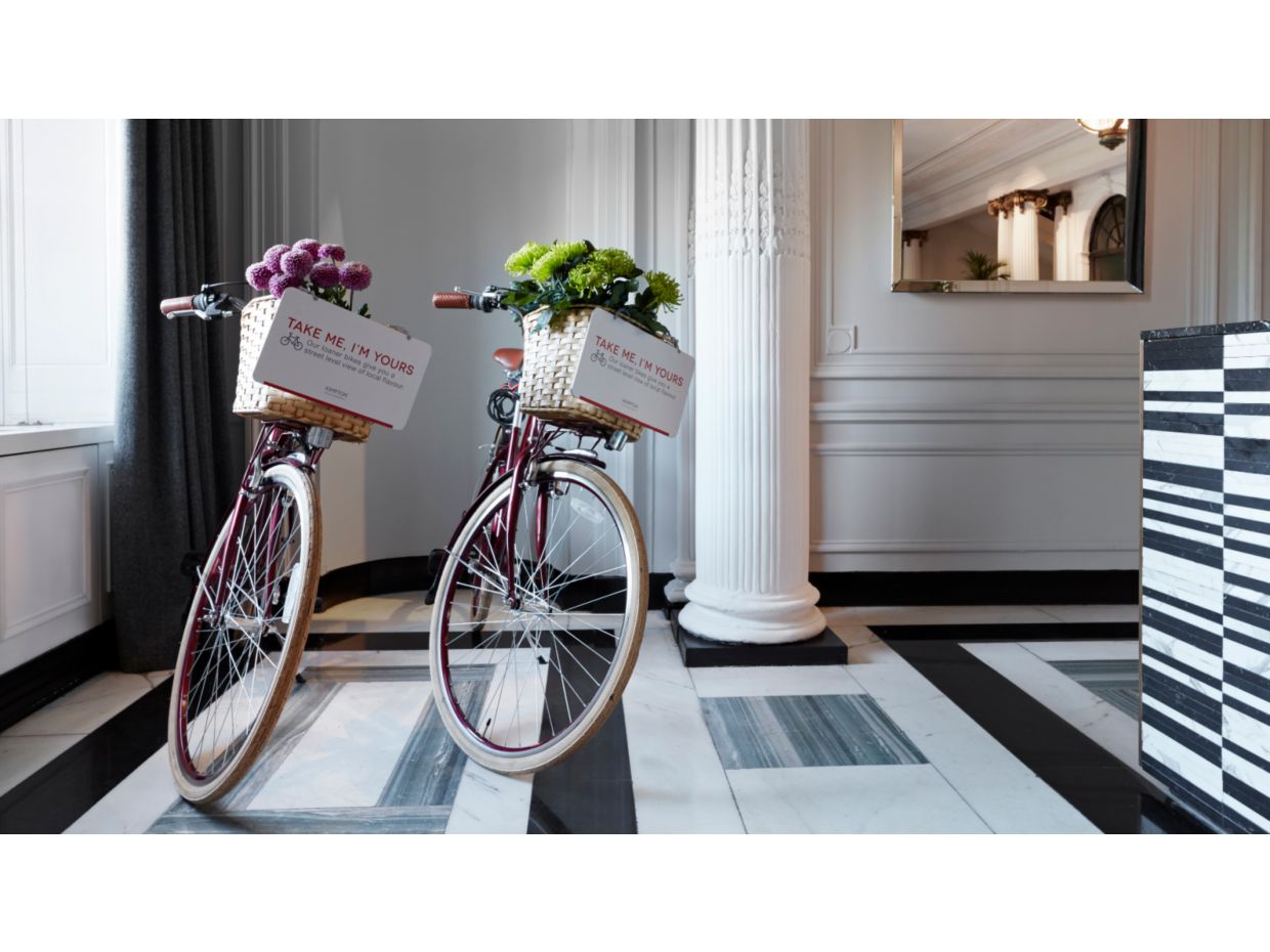 白色和灰色大理石大堂里，两辆配带花篮的自行车