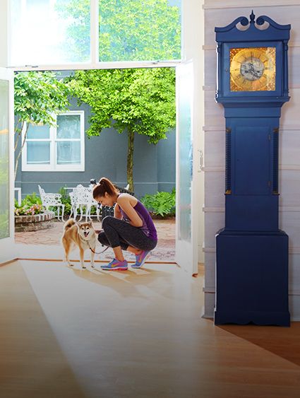 一名穿着运动服的女士在抚摸拴着的狗