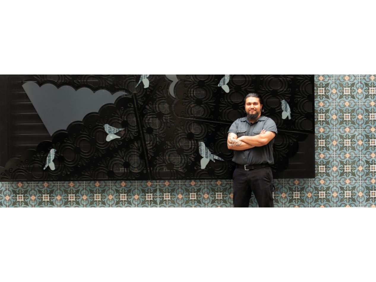 A professional staff member folding his arms and smiling