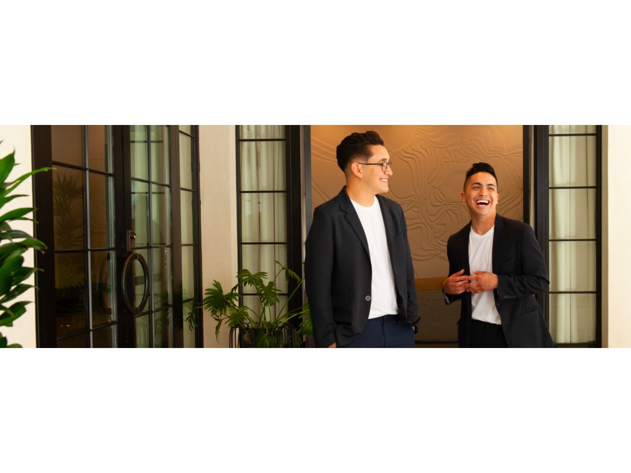 Two well-dressed men smiling and laughing