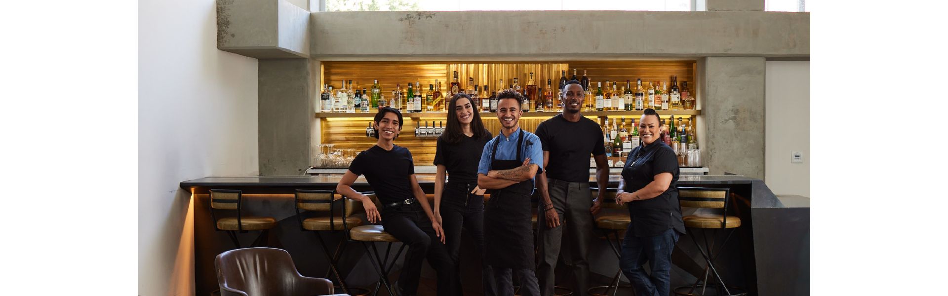 group of employees hanging out in front of bar and windows with mountain views