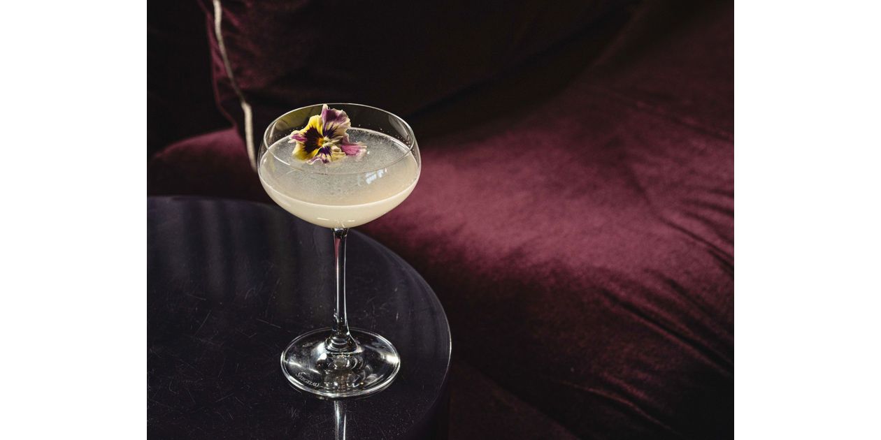 浓艳绯红的座椅旁，侧桌上一杯特调美酒静置