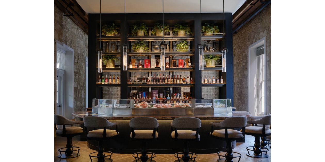 户外用餐区域位于木质露台，周围热带树木环绕，可眺望壮丽海景