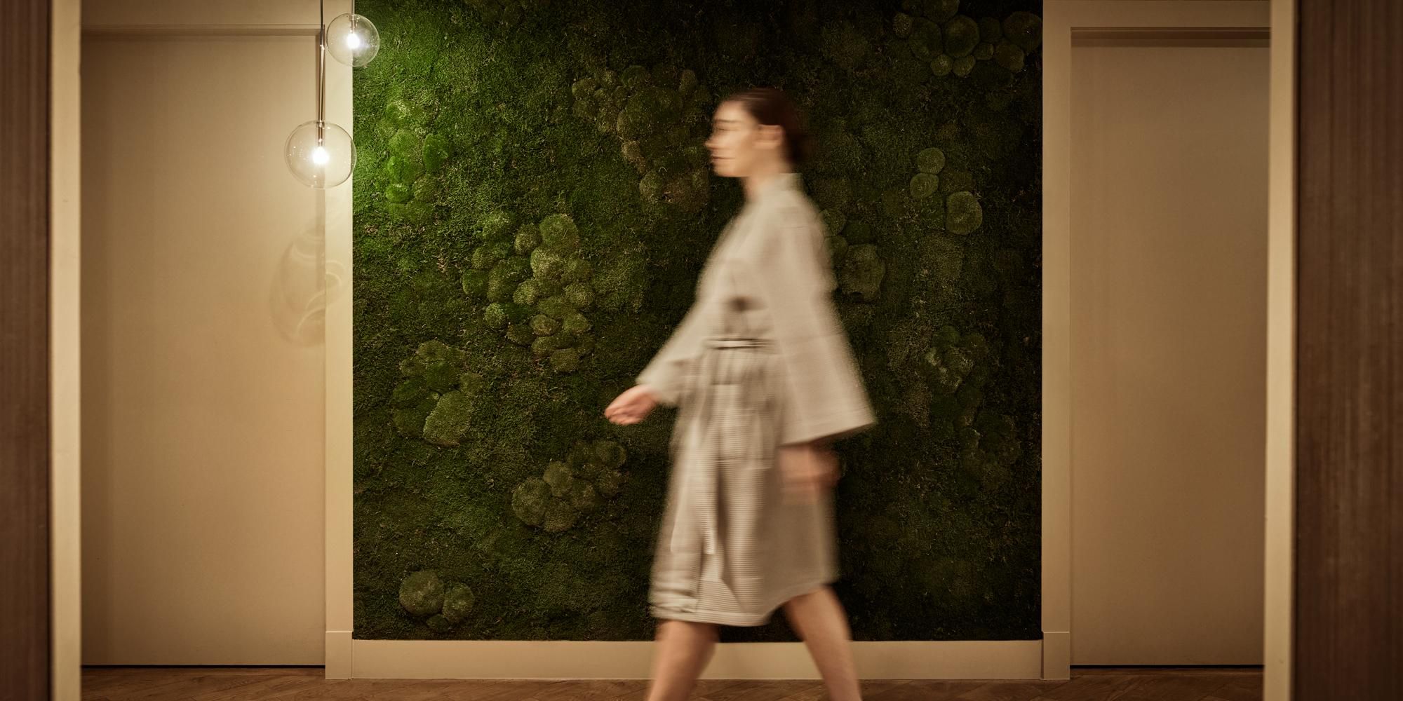 Robed woman walking down the treatment corridor