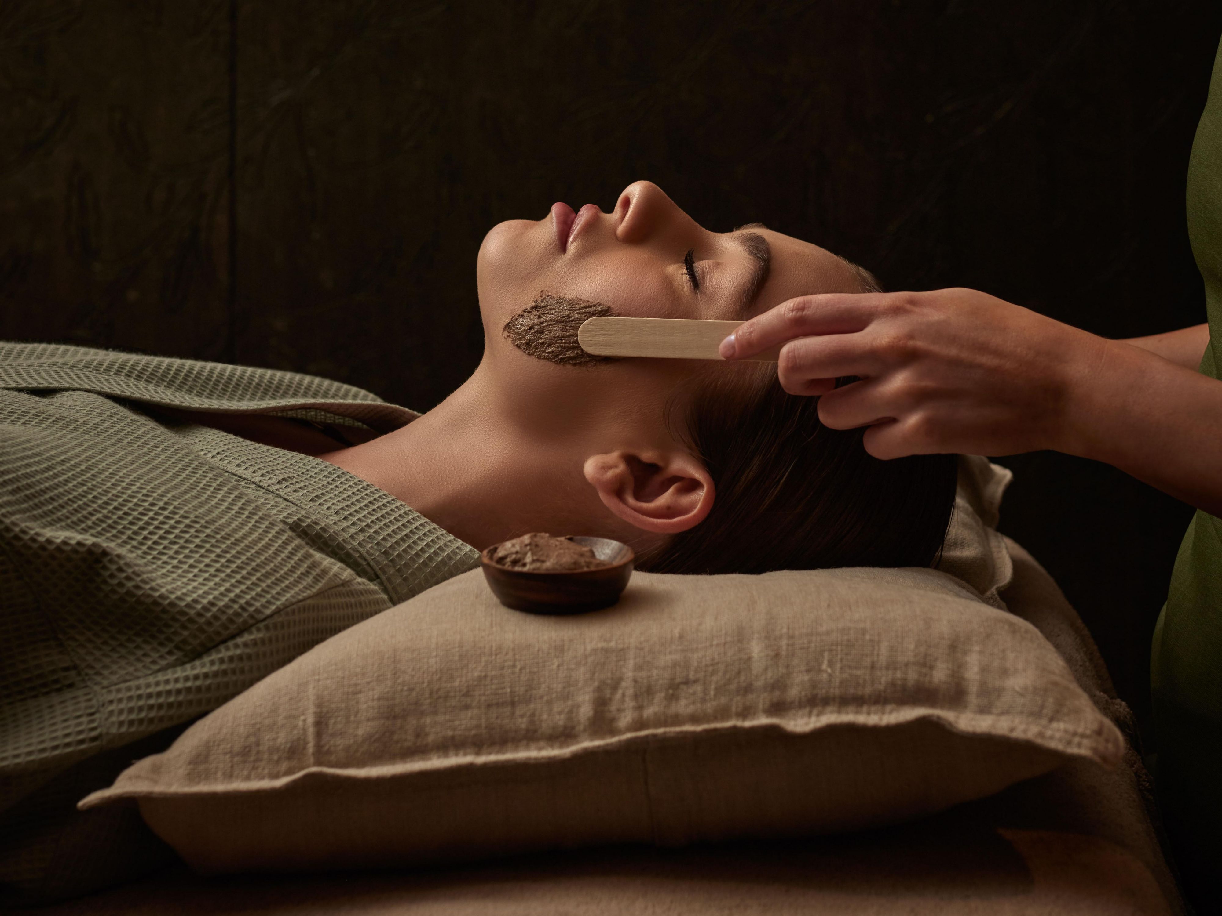 Woman getting a mud mask applied