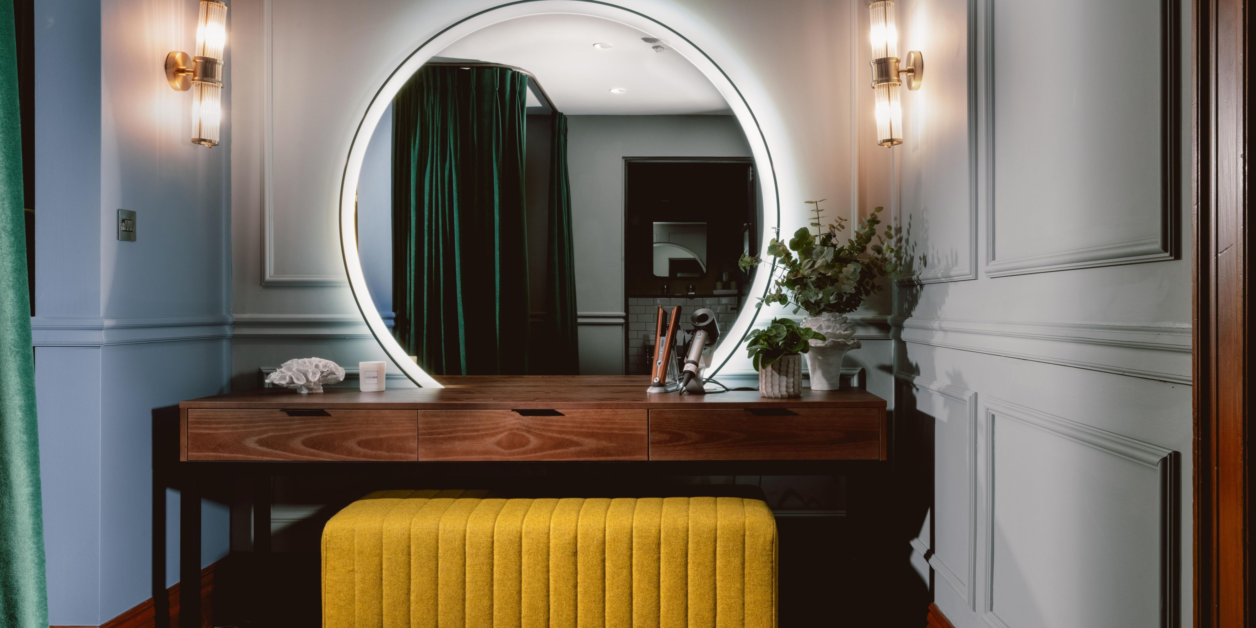 Dressing table in a luxury hotel suite with Dyson products and large circular mirror