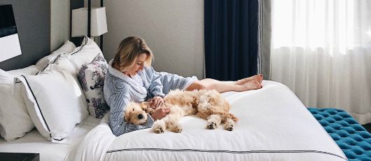 一位女士和她的狗狗依偎在床上