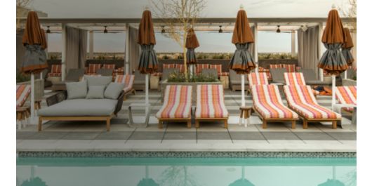 striped cabanas around a pool with views of the mountains at sunset