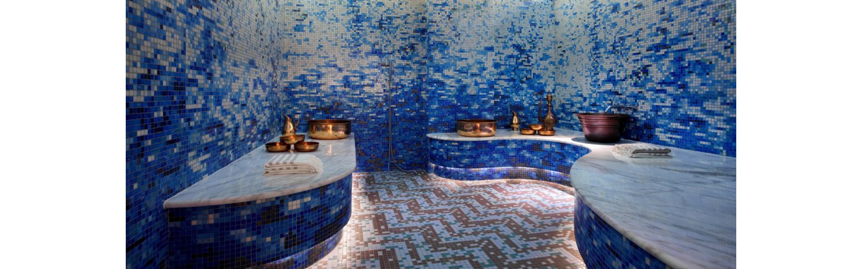 墙上用蓝色马赛克瓷砖装饰，搭配白色大理石的水疗室