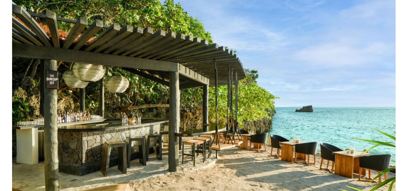 配备餐椅的户外酒吧坐落于沙滩一隅，离海边仅咫尺之遥