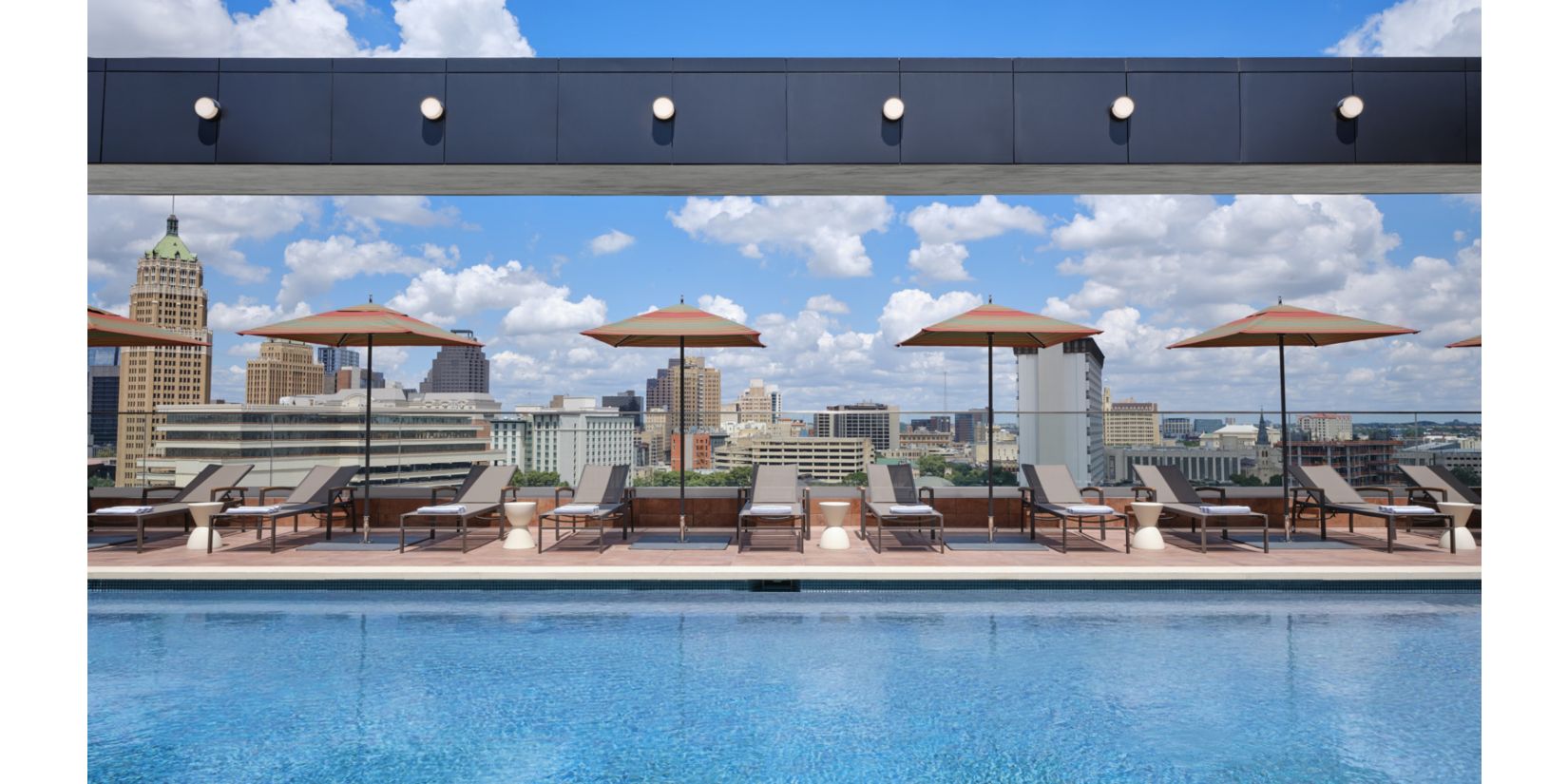 附带躺椅和遮阳伞的屋顶泳池